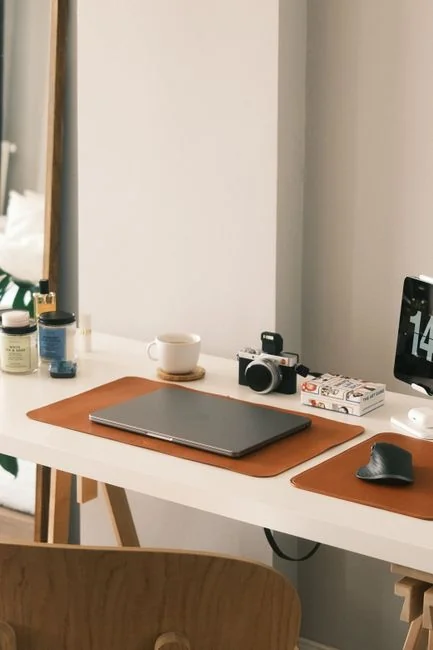 A laptop resting on a bed displays web design software, forming a cozy workspace.